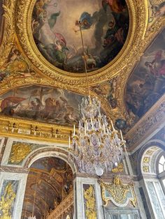 an ornately decorated room with chandelier and paintings