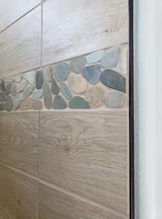 a bathroom with wood and stone tile on the wall