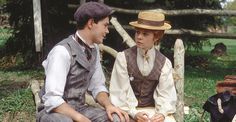 an old black and white photo of two people sitting next to each other