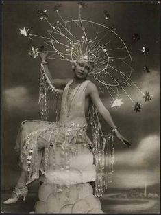 a black and white photo of a woman sitting on top of a cake with stars