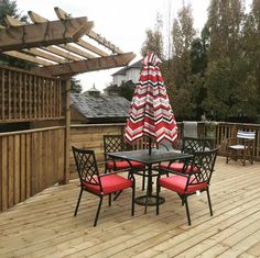 an outdoor table and chairs on a wooden deck