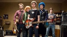 a group of young men standing next to each other with guitars in front of them