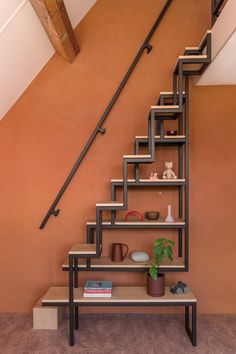 a set of stairs leading up to the second floor in a house with an orange wall