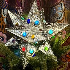 an ornament is hanging on a christmas tree with ornaments around it and in front of a colorful background