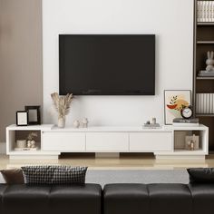 a large flat screen tv mounted to the side of a white wall in a living room