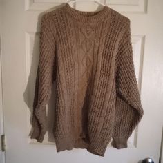 a brown sweater hanging on a white door