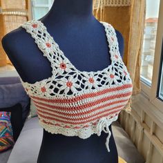 a mannequin wearing a crocheted top with red and white stripes on it