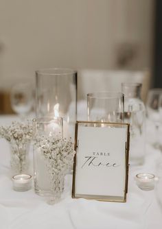 the table is set up with candles, flowers and place cards for guests to sign