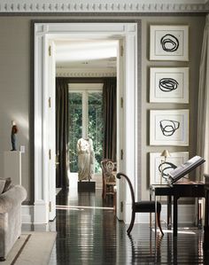 a living room filled with furniture and pictures on the wall above it's doorway