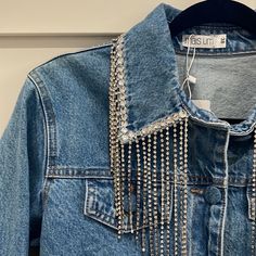 a denim jacket with chains hanging from it