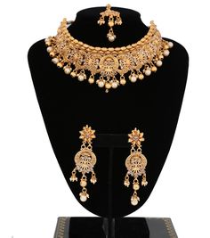 "A magnificent Luxury bridal necklace set for the brides.Premium quality gold plated, antique design, and studded with small clear stones and beautify with round golden beads and pearls droppings. Necklace comes with matching earrings and maang tikka. 1 x Necklace approx. 4.5 inches Collar-Wide . Back adjustable rope is attached. 1 x Pair of Earrings 3.5\" Length from top to bottom. *Adjustable & Appropriate for All Neck Sizes.Perfect for a bride in wedding or party wear jewelry set. Visit m Gold Choker Jewelry Set For Reception, Gold Choker With Intricate Design For Wedding, Gold Choker For Wedding And Festive Occasions, Gold Wedding Choker With Intricate Design, Gold Festive Wedding Choker, Gold Wedding Choker For Festive Occasions, Traditional Gold Choker For Reception, Gold Kundan Choker With Intricate Design, Gold Choker For Reception