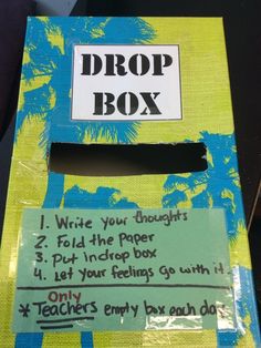 a box with writing on it that says drop box and has palm trees in the background