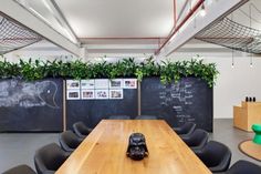 an empty conference room with wooden tables and blackboard behind the table, surrounded by chairs