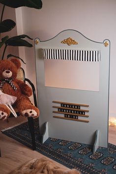 a teddy bear is sitting on a chair in front of a sign that reads,