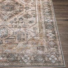 an area rug on the floor with a wooden floor and wood floors in the background