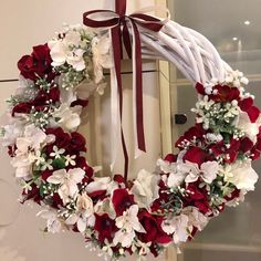 a white wreath with red and white flowers