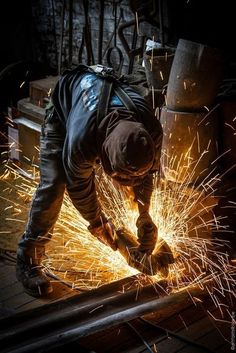 a man working on metal with sparks in his hands