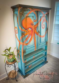 an octopus painted on the side of a blue cabinet next to a potted plant