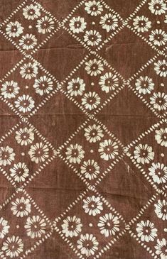 an old brown and white cloth with flowers on it