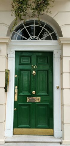 a green front door with gold trim