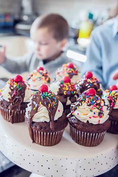 there are many cupcakes with sprinkles on the cake platter