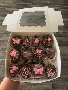 chocolate covered strawberries in a white box with pink icing and flowers on them