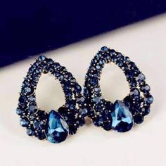 The darkest blue Austrian crystals flow in graduated sizes along a golden teardrop outline. The gold plated background creates contrast, making the blue even more alluring. A single pear shaped Austrian crystal emulates the shape of the earrings, becoming the focal point. In navy blue hues, these earrings can be dressed up or dressed down. They are totally versatile and easy to wear. Size 2.5 x 2 cm (approximately 1 inch x 1/2 inch) Materials: Gold Plated/Alloy Stones: Rhinestones Post Earrings, Sapphire Earring, Blue Drop Earrings, Cocktail Earrings, Blue Crystal Earrings, Oval Stud Earrings, Prom Earrings, Rhinestone Fashion, Luxury Earrings, Gold Jewelry Earrings