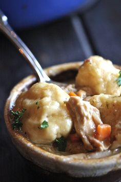 a bowl filled with meat and dumplings on top of a table