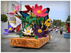 an elaborately decorated float in the middle of a street with people walking on it