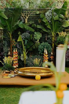 a table topped with a plate covered in food next to lush green plants and trees