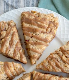 a white plate topped with slices of fruit and oatmeal cookies covered in peanut butter