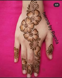 the hand is decorated with flowers and swirls on pink fabric, as if it were hendi