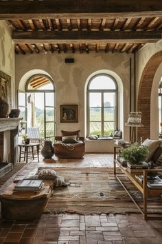 a large living room with arched windows and stone flooring is pictured in this image