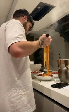 a man is cooking pasta in the kitchen