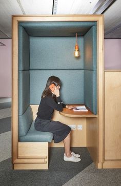 a woman sitting at a desk in an office cubicle