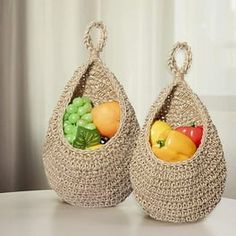 two baskets filled with different types of fruits and vegetables on top of a white table