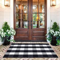 a front door with two potted plants and a no entry sign