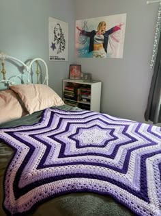 a purple and white crocheted blanket on top of a bed in a bedroom