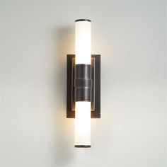 a wall mounted light on the side of a white wall with two lights in it