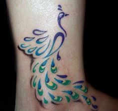 a peacock tattoo on the ankle with blue, green and yellow feathers painted on it