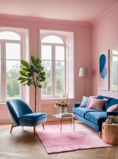 a living room with pink walls, blue couches and two chairs in front of large windows