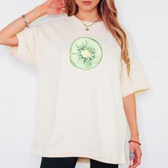 ・Kiwi Fruit Graphic Tee - Custom Boho Aesthetic Shirt with Fresh Summer Vibes・ Bring a splash of tropical flavor to your wardrobe with the Kiwi Fruit Graphic Tee. This custom boho aesthetic shirt features a fun and vibrant kiwi graphic, perfect for adding a fresh pop of color to your summer outfits. Whether you're heading to the beach, hanging out with friends, or embracing your inner foodie, this lightweight tee is designed to keep you cool and stylish. * Soft, breathable fabric for ultimate comfort * Custom kiwi fruit graphic for a trendy, eye-catching look * Ideal for those who love boho aesthetics, summer vibes, and fresh fruit designs * Perfect as a gift for foodies, fruit lovers, and fans of unique graphic tees Pair this tee with jeans, shorts, or skirts for a casual, laid-back summe Oversized Y2k T-shirt For Summer, Y2k Fruit Print Short Sleeve Tops, Y2k Style Fruit Print Short Sleeve Tops, Y2k Short Sleeve Top With Fruit Print, Relaxed Fit Crew Neck Top With Fruit Print, Summer Y2k T-shirt With Fruit Print, Green Short Sleeve Top With Fruit Print, Fruit Print Graphic Tee With Crew Neck, Fruit Print Crew Neck Graphic Tee