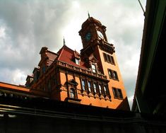 a large building with a clock on the side of it's face and sky in the background