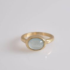 "Beautiful 14k gold ring with blue aquamarine stone for a woman. This 14k gold ring is a perfect, unique, modern ring for every woman. This Aquamarine gold ring is relatively heavy yet maintains a gentle look. The bezel of the ring is intentionally wider then in typical engagement ring bezel, so you can see more gold around the cabochon aquamarine stone. Dimensions: * 14k solid gold * Aquamarine : 8 * 10 m\"m I use natural gemstones in my jewelry which I hand pick myself and although I make ever Aquamarine Ring Gold, Oval Aquamarine Ring, Aquamarine Gold Ring, Small Dangle Earrings, Bezel Engagement Ring, Gold Statement Ring, Solid Gold Ring, Solid Gold Earrings, Aquamarine Ring