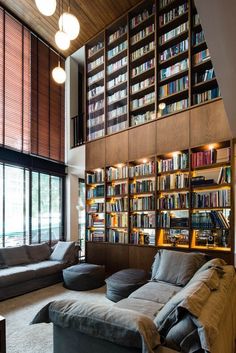 a living room filled with lots of furniture and bookshelves next to a window