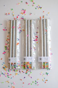 four silver confetti straws with sprinkles on them