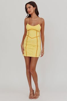 a woman wearing a yellow dress with spaghetti straps