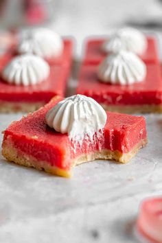 several pieces of dessert sitting on top of a baking sheet with meringue and whipped cream