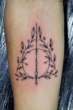 a tattoo with an arrow and leaves on it