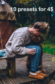 a woman is sitting on a bench with her dog